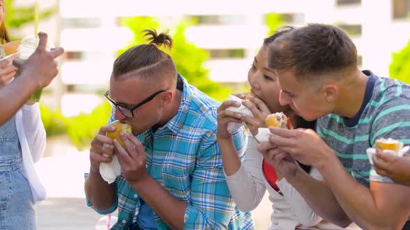 Friends Eating Burgers or Sandwiches in Park 89