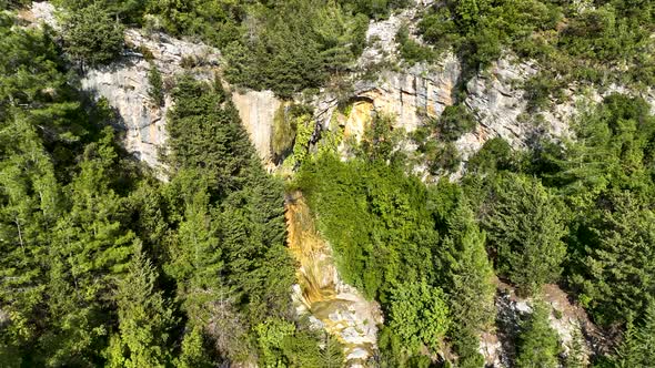 A small waterfall in the mountains aerial view 4 K