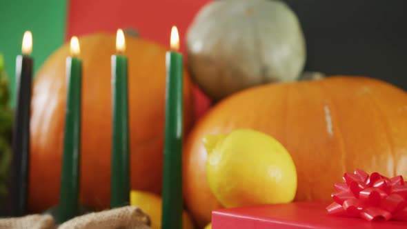 Composition of six lit candles and halloween pumpkins and vegetables