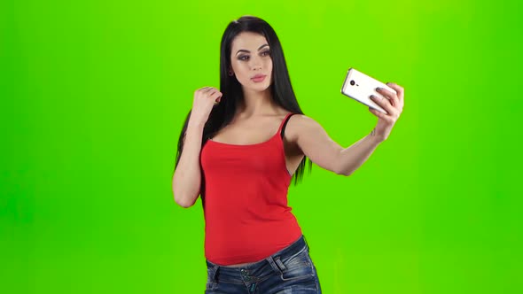 Brunette Girl Making Selfie Photo Using a Smartphone 