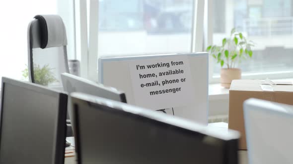 Sign Hanging on Computer Monitor in Empty Office