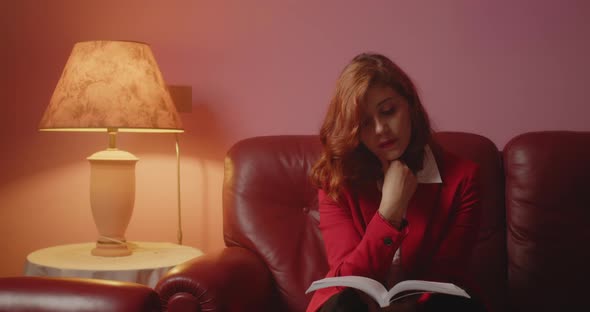 Beautiful girl with red jacket reads the book