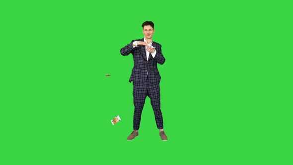 Young Happy Businessman Dancing and Throwing Money on a Green Screen, Chroma Key.