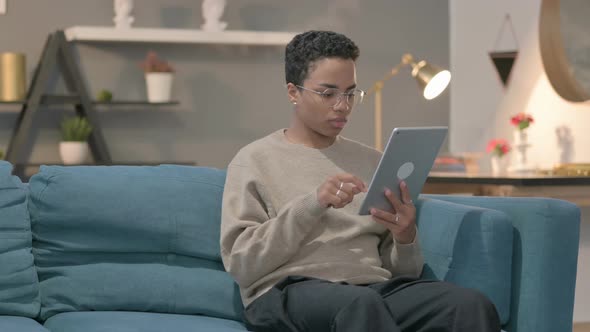 African Woman Having Loss on Tablet on Sofa