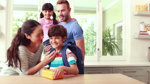 Mother Giving to her Son Lunch Box