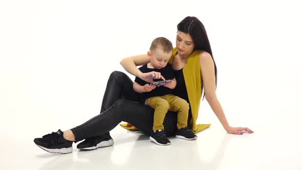 Mom and Child Are Watching Cartoons on a Smartphone