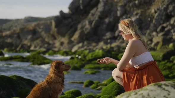 4k Slow Motion Happy young woman playing with her pet dog on the Guincho beach in Portugal. Throwing