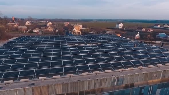 Flat roof with solar panels on it. Additional source of power for supplying factory with electricity