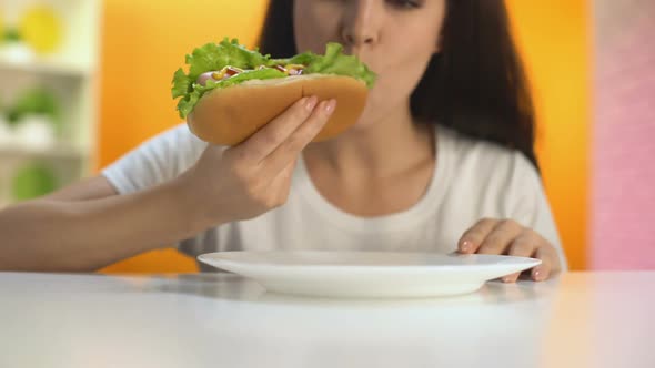 Young Female Biting Delicious Hot-Dog and Smiling, Lunch Break in Restaurant