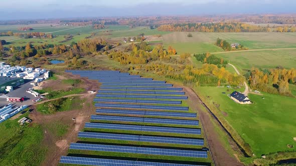 Aerial view of solar panel rows near a factory during Autumn, Estonia.