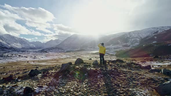 A man stands on top of a cliff and enjoys a beautiful view. Adventure and travel concept.