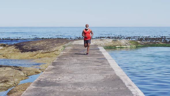 Senior african american man exercising running on road by the sea