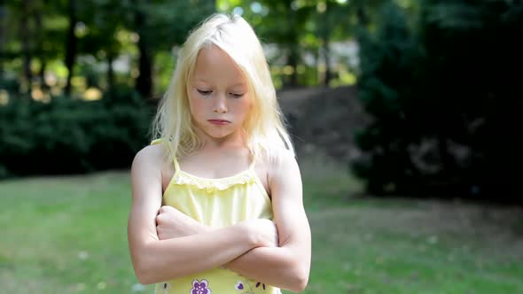 Little Girl Offends in the Park - She Based Her Arms and Pouting Her Lips