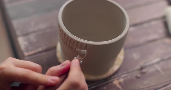 The Potter Uses a Knife to Decorate Clay Bowl