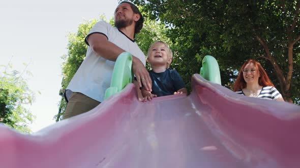 Young Family on the Walk  Little Boy Rolling Down the Slide