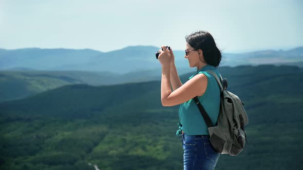 Hipster Travel Woman Standing on Top of Mountain Taking Photo Use Camera