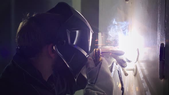 The Welder Man Working in a Factory and Sparks Flying