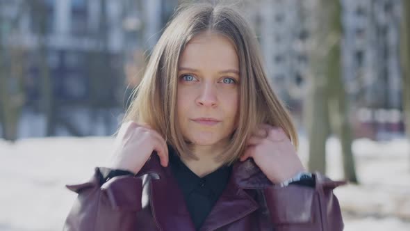 Attractive Caucasian Woman Turning Up the Collar on Purple Coat Looking at Camera with Confident