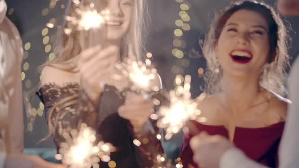 Asian Girl and Group Young College Student Friends Lit Light Sparkler in Hand Fireworks Sing and