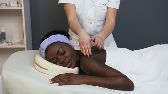 African Young Woman During Massage in the Spa Salon