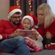 Family Choose New Years Gifts in Online Store By Tablet Next to Christmas Tree - VideoHive Item for Sale