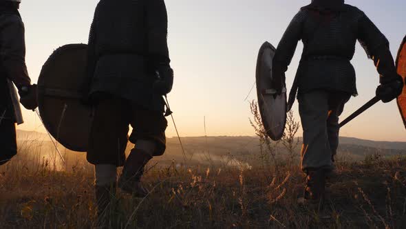 Silhouettes of Viking Warriors Gather and Stop in the Field and Watch the Beautiful Sunset.