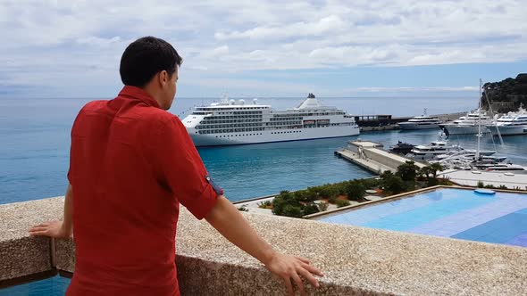Businessman in Casual Clothes Observing His Yacht in Port, View From Terrace