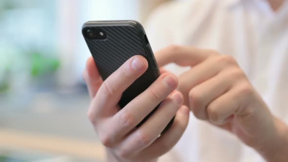 Close Up of Hands of Young Man Using Smartphone