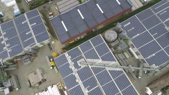 Drone lifting up over industrial roof with solar panels.