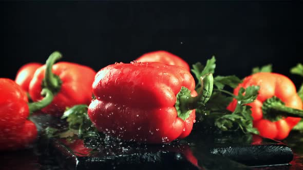 Sweet Peppers Fall on a Cutting Board with Splashes of Water