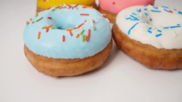 Delicious Multicolored Glazed Donuts in a Smooth Motion