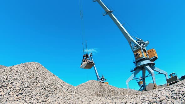 Industrial Crane Carries Rubble in a Metal Bucket