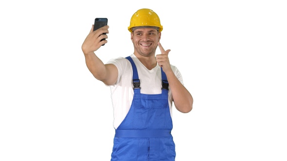 Smiling handsome young builder making selfie with mobile