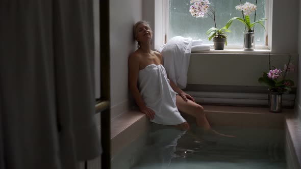 Beautiful mature woman in historic Roman Bath in Berkeley Springs State Park with lotus flowers and