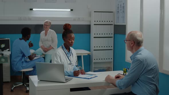 Doctor Consulting Elder Patient with Sickness in Medical Office alt