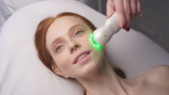 Attractive Woman in a Cosmetology Clinic Receives a Phonophoresis Procedure for the Skin of the Face