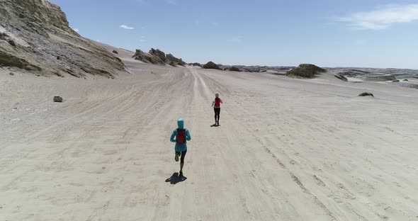 Two women trail runners cross country running in the desert