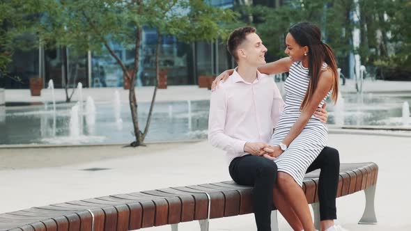 Cheerful Multiracial Couple Having Date Outdoors Near the Fountains