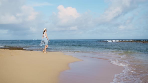 Beautiful Slow Motion Shot of Woman in Blue Flowing Beach Dress Walking Barefoot