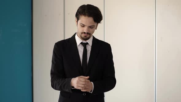 self-confident young businessman adjusts his shirt cuffs