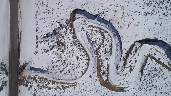 Panning aerial view looking down at dry river winding