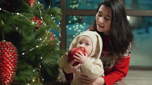 Baby Looks at Toys on Christmas Tree Xmas