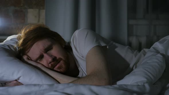 Uncomfortable Man Sleeping in Bed at Night