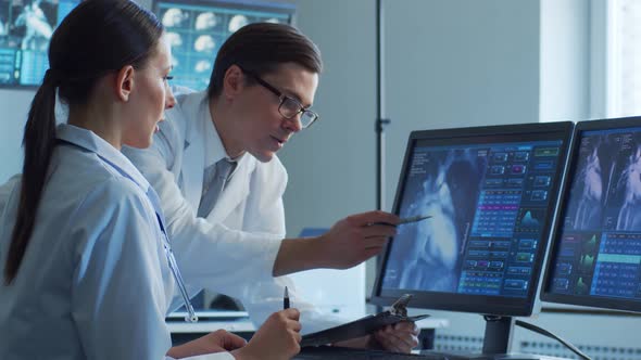 Professional medical doctors working in hospital office making computer research.