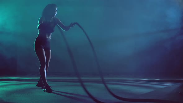 Muscular Brunette Woman Doing Battle Rope Training