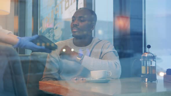 African Man is Paying a Cafe Bill with His Smart Watch