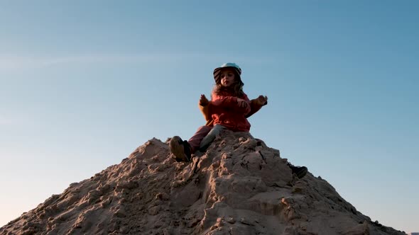 Little Brother and Sister Sit on Large Sand Pile and Play