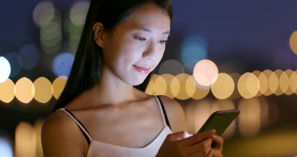 Asian woman use of cellphone at night