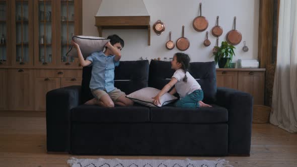 Children Play with Pillows on the Couch