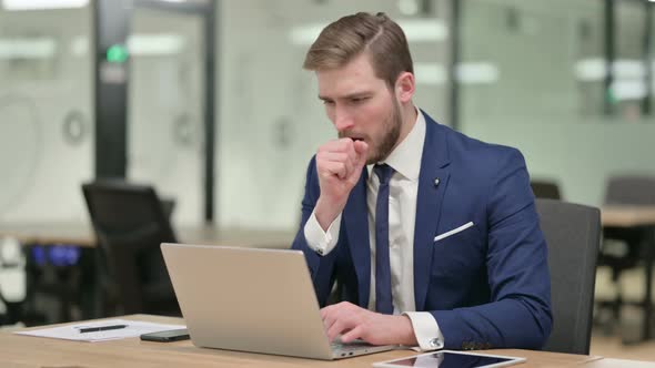 Young Businessman Having Coughing While Working on Laptop